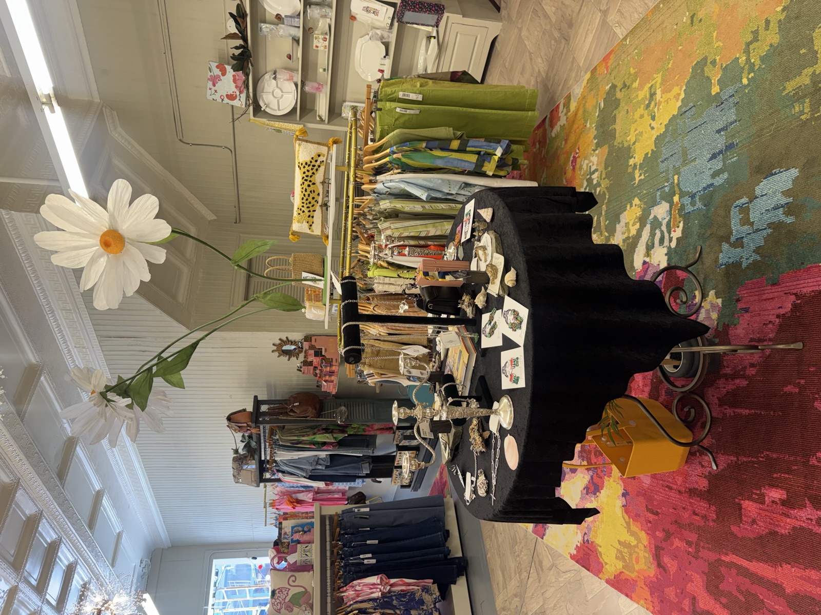 Giant paper daisies over the black-velvet jewelry table