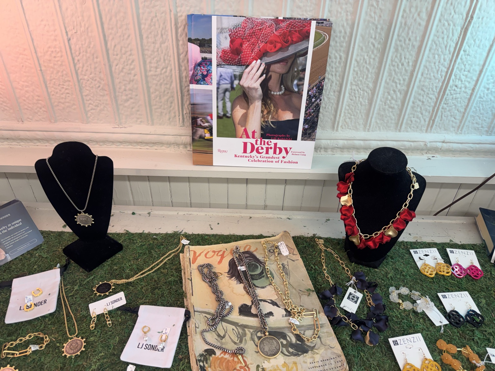 Gold necklaces and jewelry styled with books on the display table