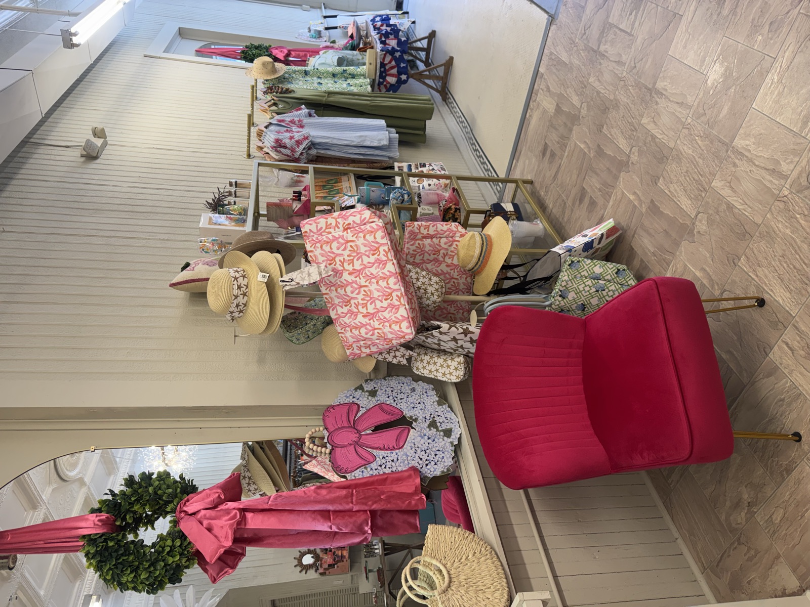The raspberry velvet chair beneath a pink-bowed wreath and arched mirror